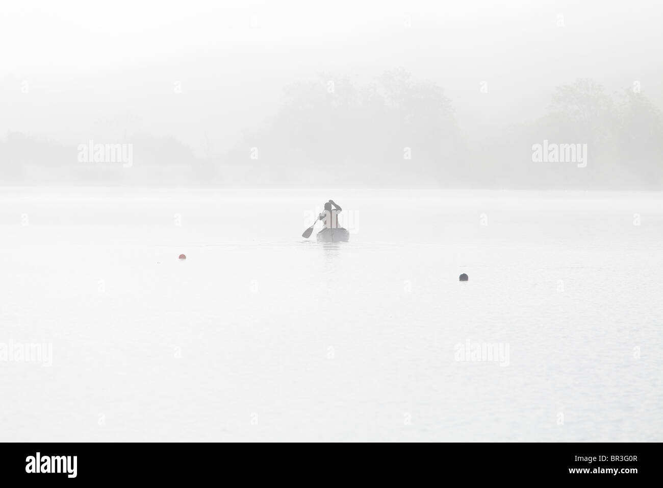 Un uomo in kayak in una mattina misteriosa sul Castello Semple Loch nel Clyde Muirshiel Regional Park, Lochwinnoch, Renfrewshire, Scozia, Regno Unito Foto Stock