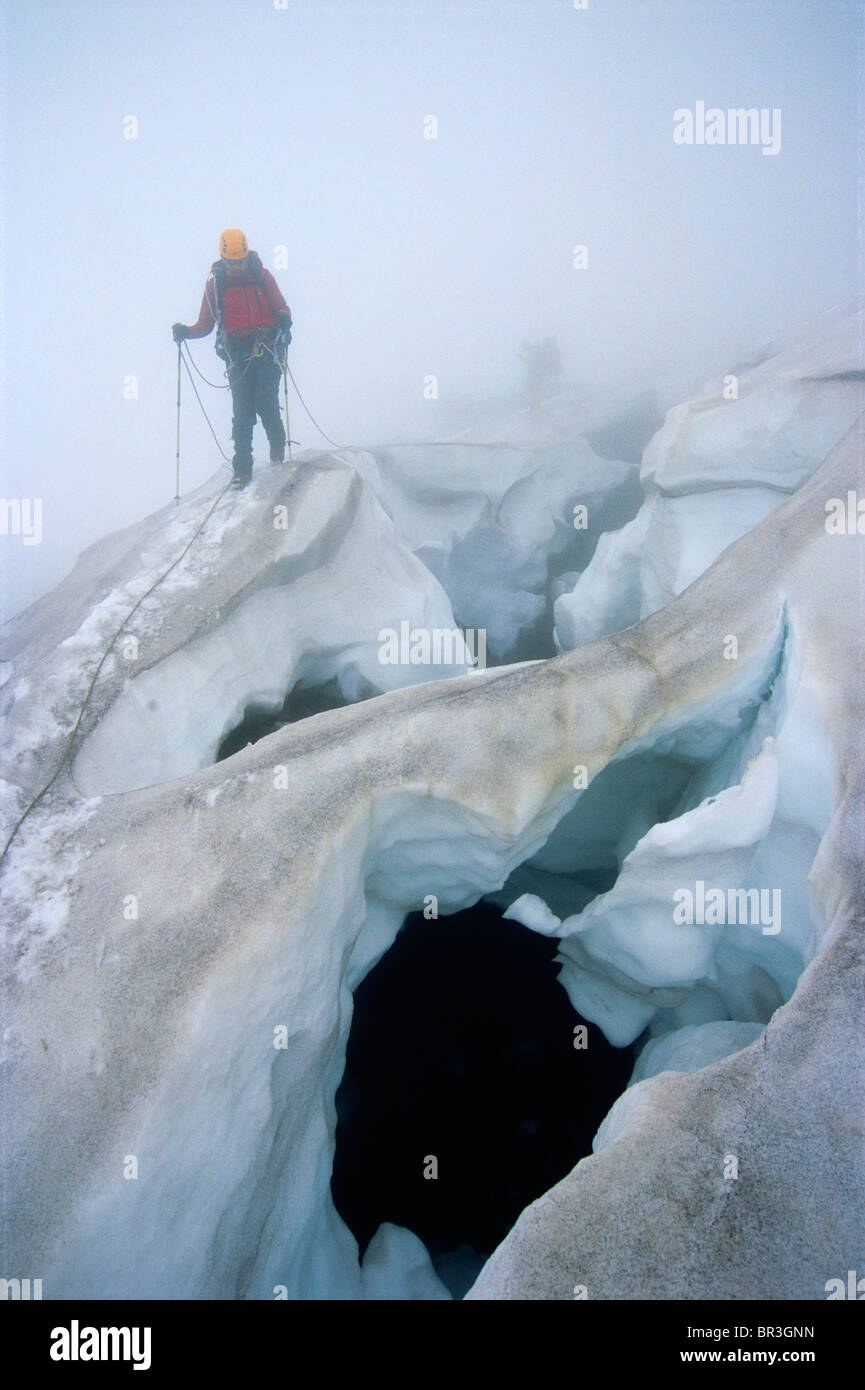 Gli alpinisti incrocio pericoloso crepacci nella nebbia Foto Stock