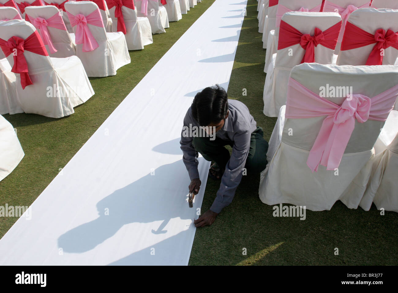 Un uomo si prepara la decorazione per un imminente matrimonio indiano a Nuova Delhi in India Foto Stock