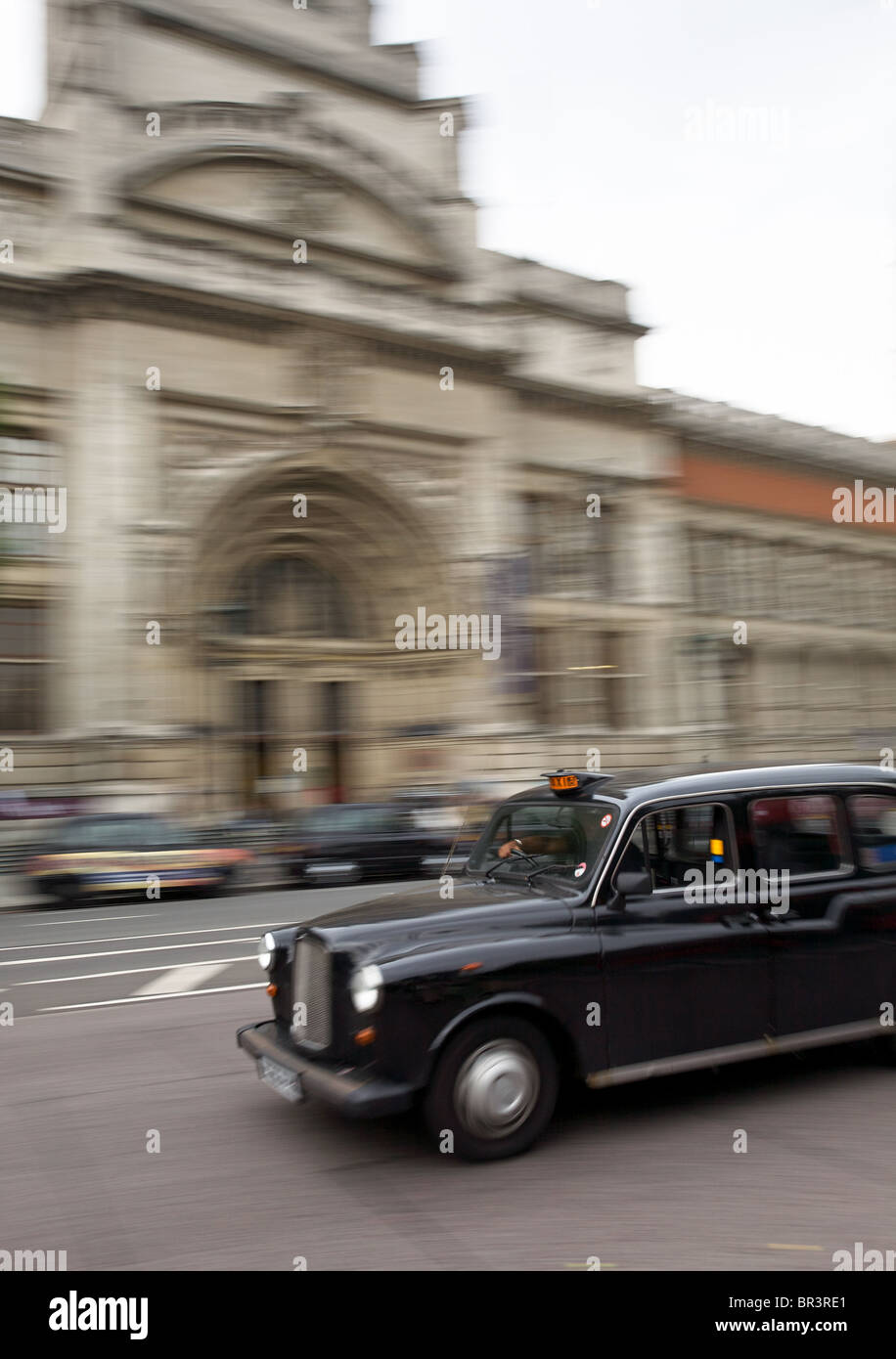Taxi passando il Victoria and Albert Museum di Londra Foto Stock