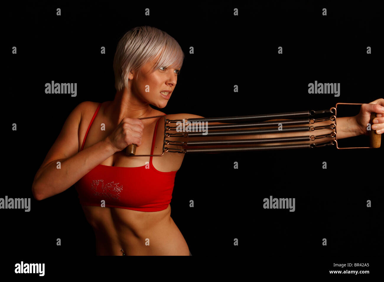 Esercizio con un espansore di petto come parte di un programma di fitness per ottenere un busto di grandi dimensioni Foto Stock