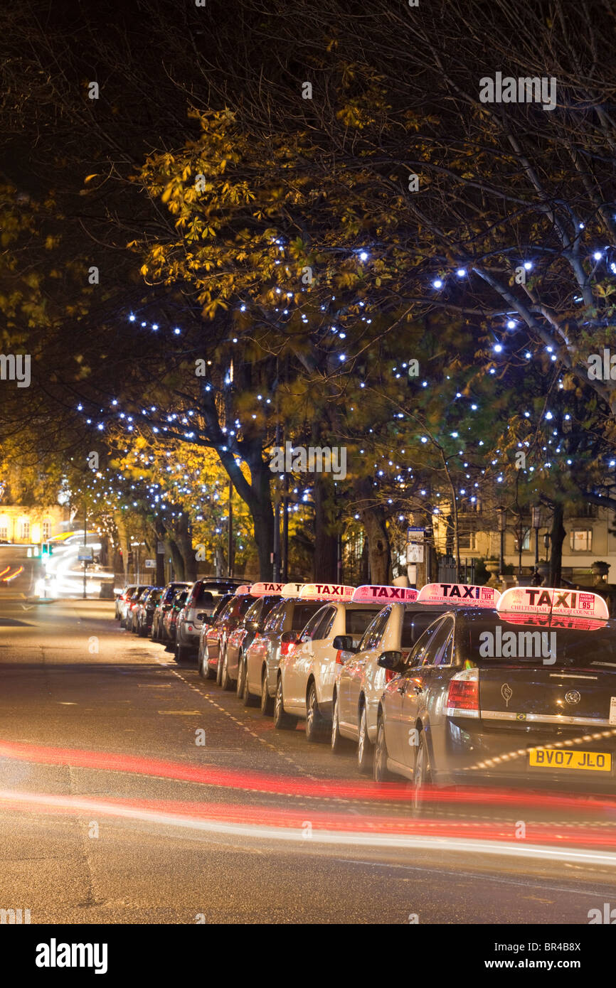 Una stazione di taxi di notte con le luci di Natale, Cheltenham, Gloucestershire, Regno Unito Foto Stock