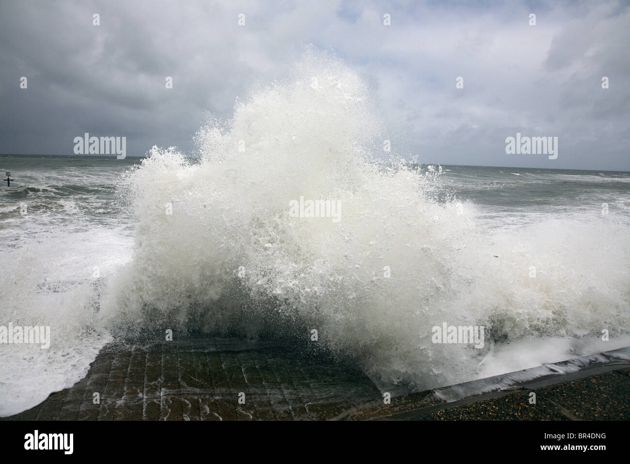 Mare tempestoso onde si infrangono contro una parete di mare sulla costa di Norfolk. Foto Stock