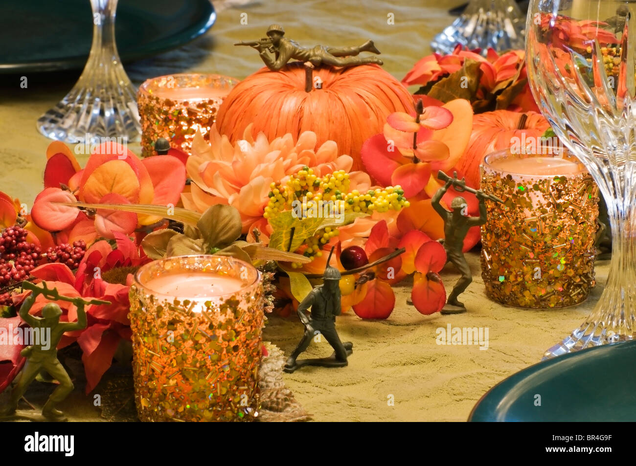 A tema militare autunno centrotavola riempie la tavola con fiori di seta, paglia zucche, incandescente a lume di candela e giocattolo di plastica soldati. Foto Stock