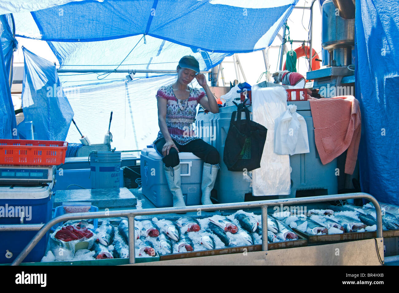 Donna vendita di salmone dalla barca da pesca Foto Stock