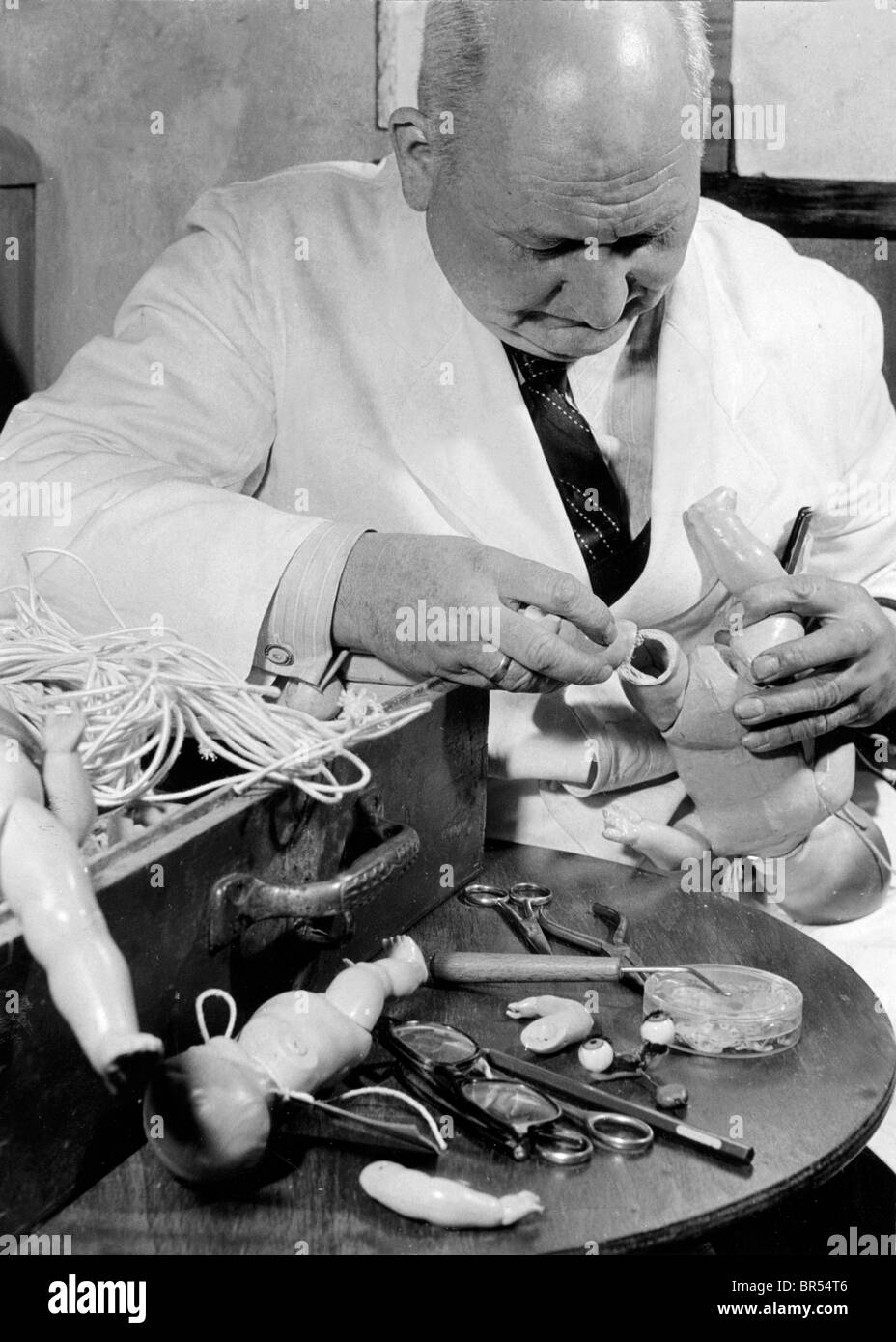 Fotografia storica, l'uomo la riparazione di bambole, intorno al 1931 Foto Stock