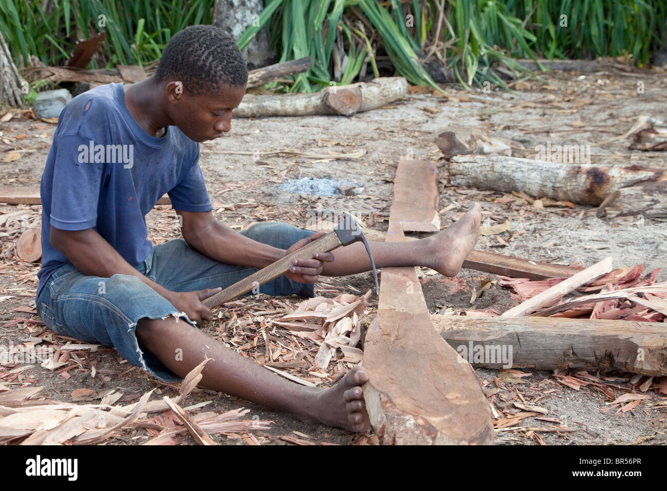 Nungwi, Zanzibar, Tanzania. Dhow Costruzione, Boat Building. Carpenter lavora con un adze. Foto Stock