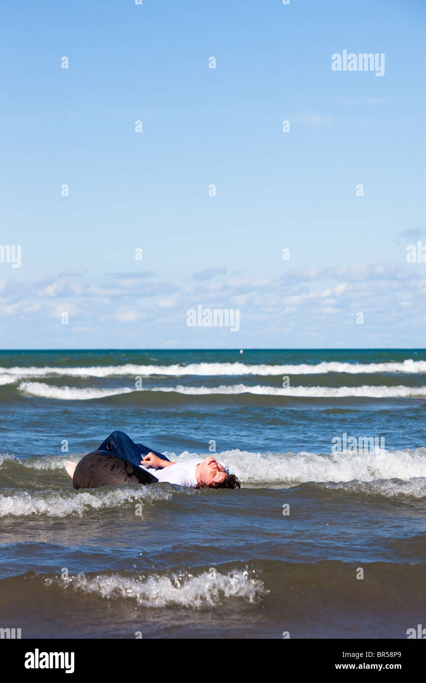 Un adolescente alla deriva nell'oceano Foto Stock