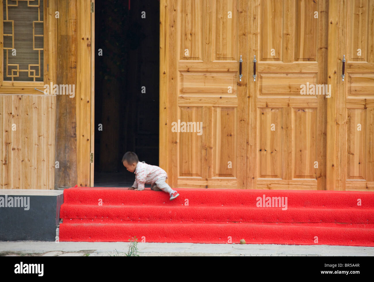 Il Toddler salendo le scale, Longsheng, Guangxi, Cina Foto Stock