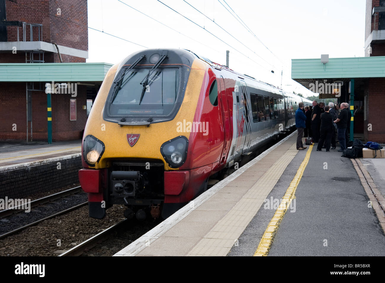 Una Vergine Voyager express treno passeggeri arrivando alla stazione Wigan North Western Foto Stock