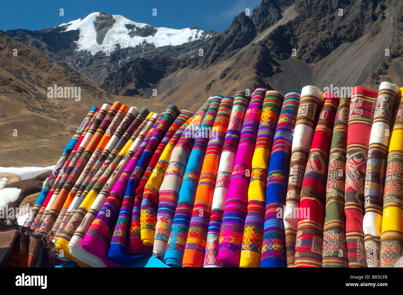 Tessuti colorati e vestiti per la vendita presso la stazione di La Raya Pass, la quota massima sulla strada da Cusco a Puno, Perù. Foto Stock