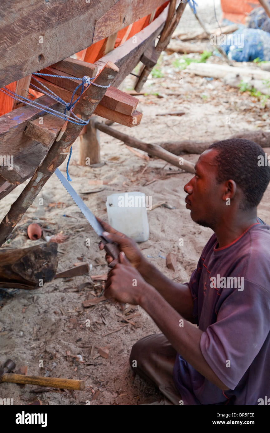Nungwi, Zanzibar, Tanzania. Dhow Costruzione, Boat Building. Carpenter al lavoro. Foto Stock