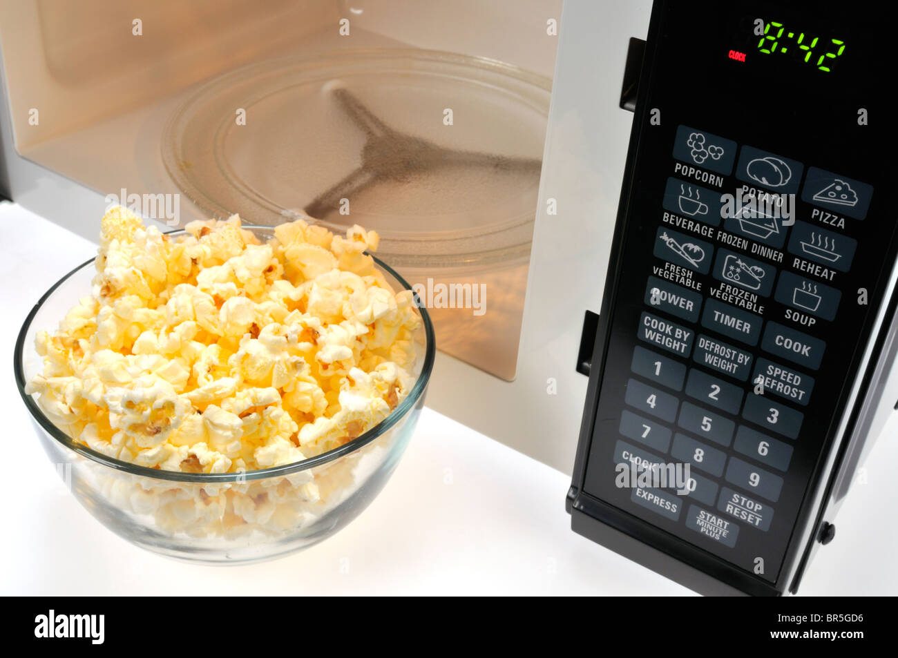 Ciotola di vetro di cotto popcorn a microonde nella parte anteriore del  forno a microonde Foto stock - Alamy