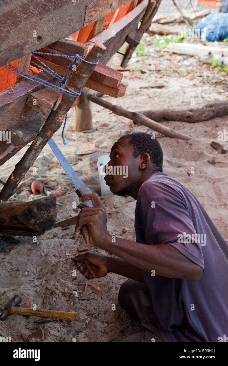 Nungwi, Zanzibar, Tanzania. Dhow Costruzione, Boat Building. Carpenter al lavoro. Foto Stock