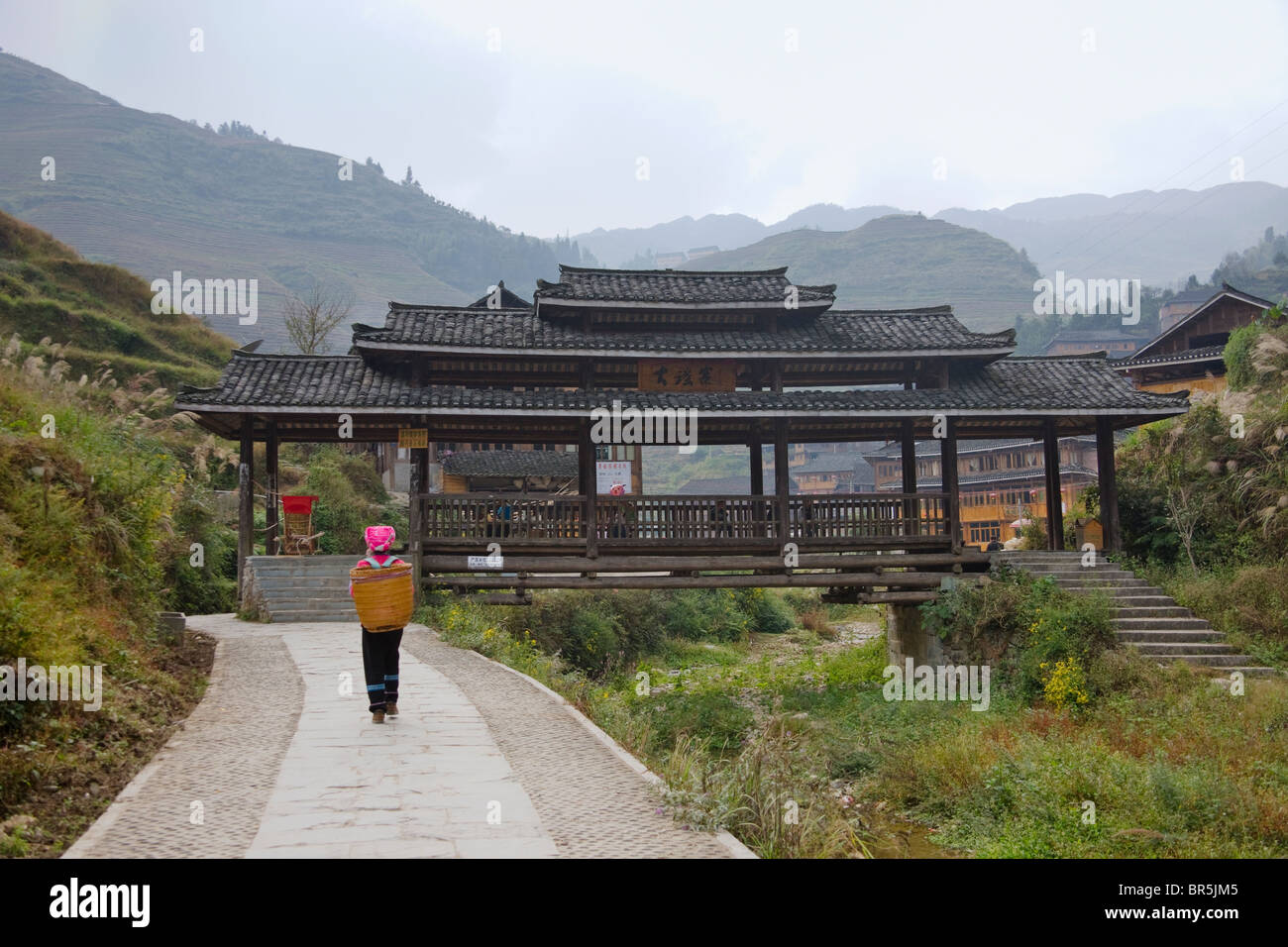 Zhuang ragazza con tradizionale Wind-And-Rain-Bridge, Longsheng, Guangxi, Cina Foto Stock