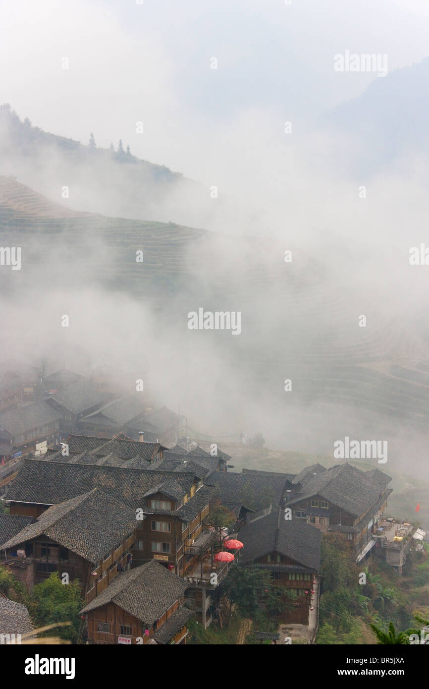 Case di villaggio in montagna nella nebbia, Longsheng, Guangxi, Cina Foto Stock