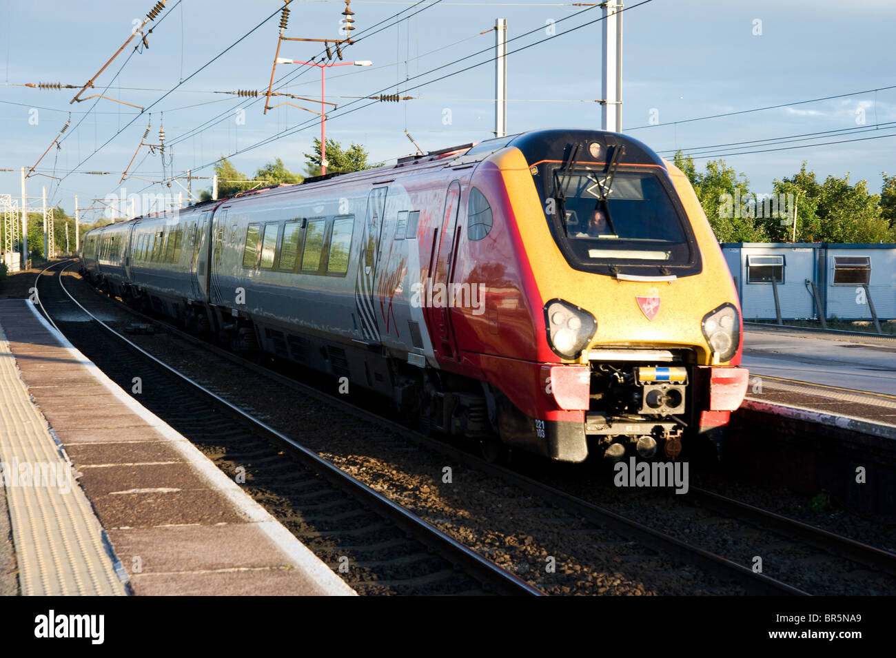 Una Vergine Voyager express treno passeggeri arrivando alla stazione Wigan North Western Foto Stock