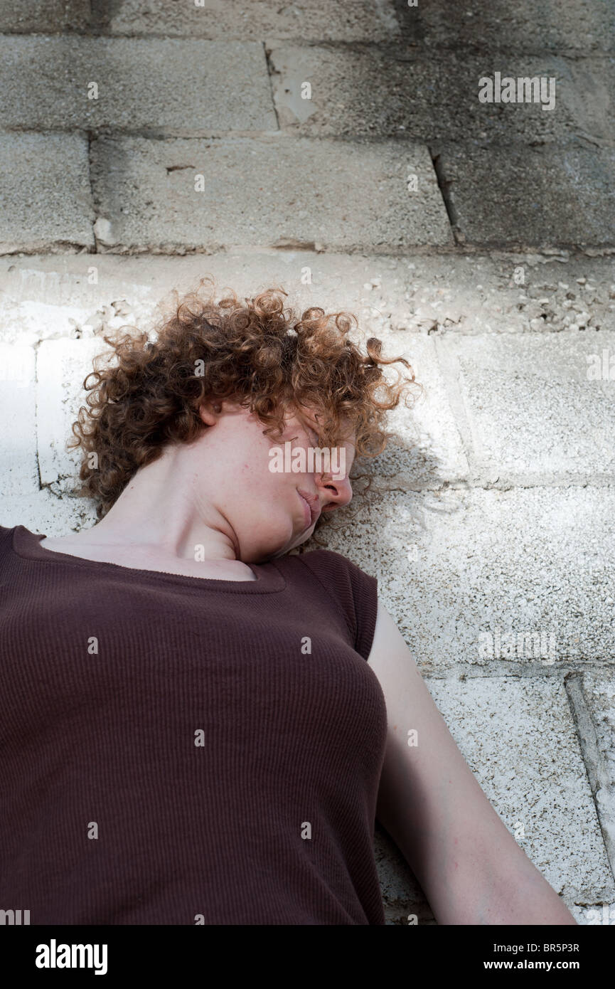 Un red head lady contro un bianco muro di mattoni Foto Stock