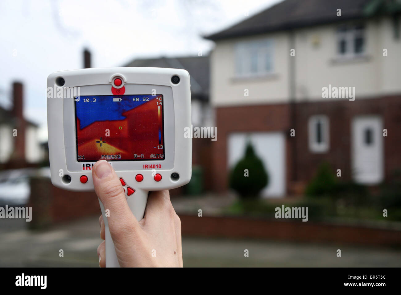 Una mano fotocamera termografica è utilizzato per testare l'efficienza di isolamento in una casa. Foto Stock