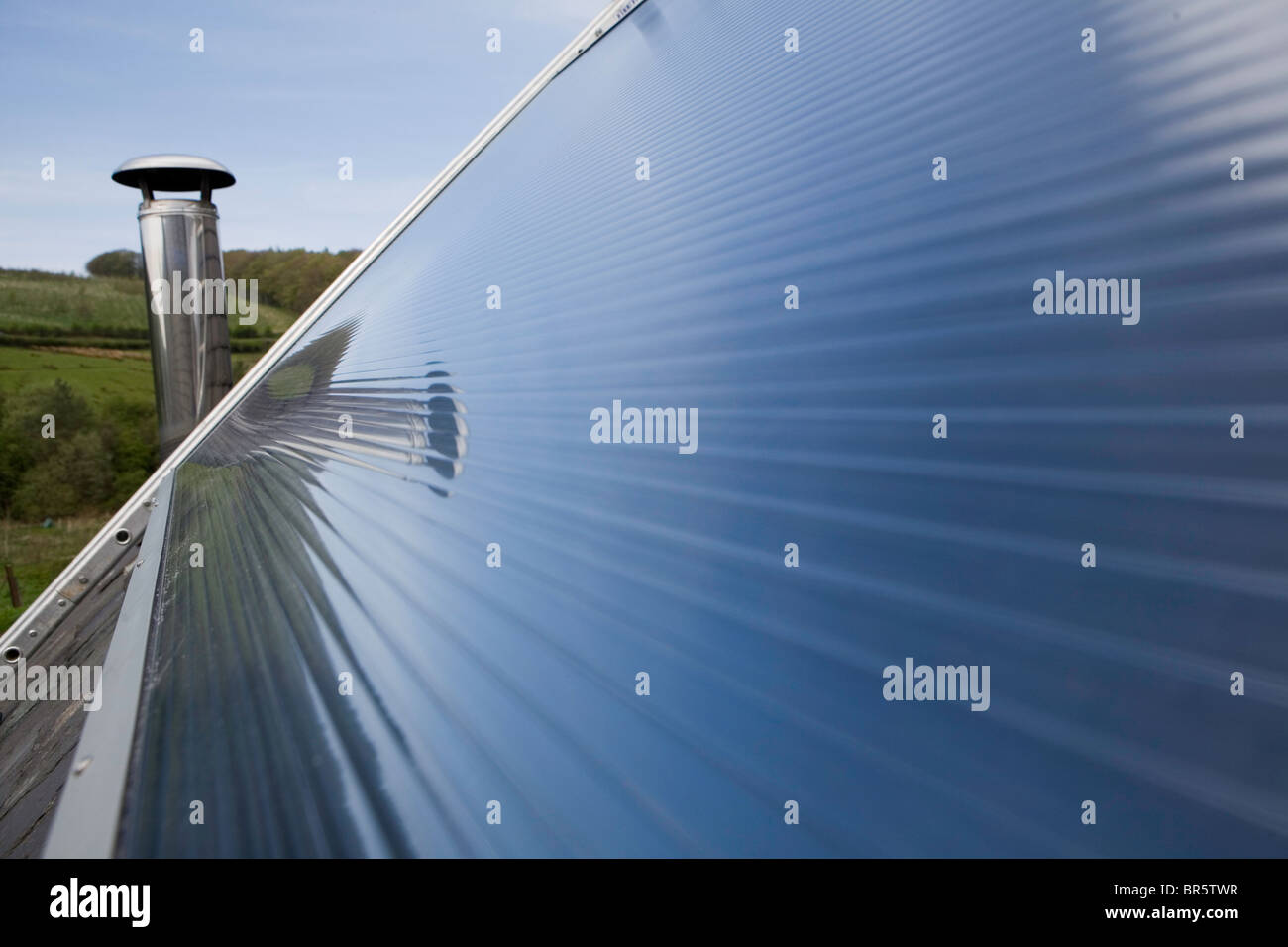 Un solare pannello termico su un tetto. Riscaldamento di acqua solare sistemi utilizzano il calore dal sole per lavorare al fianco di convenzionali di riscaldamento dell'acqua. Foto Stock
