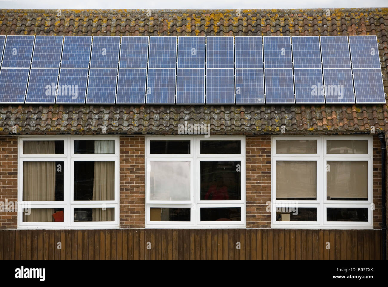 PV solari fotovoltaiche pannelli sul tetto del Ringmer Community College. Foto Stock