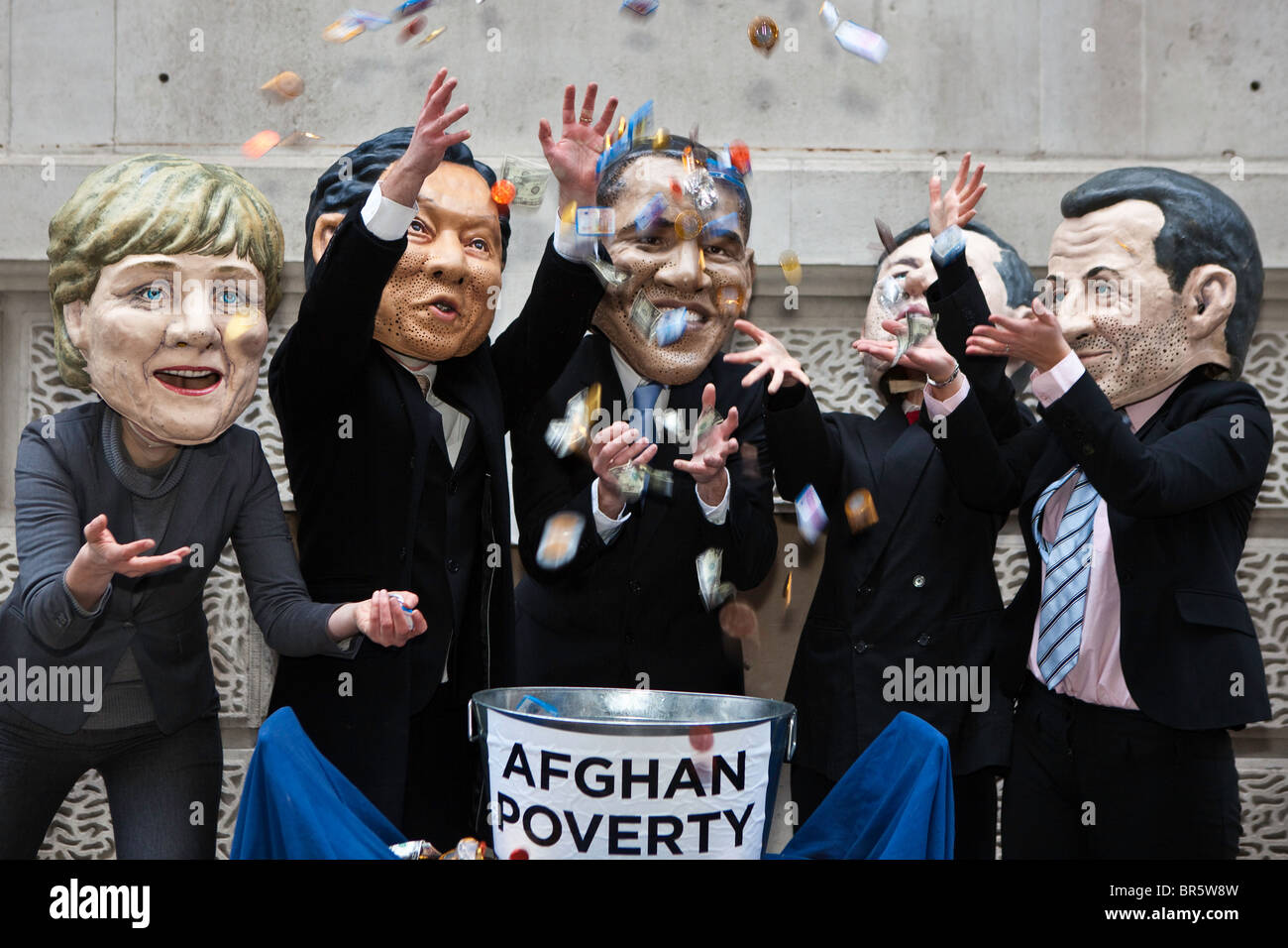 I manifestanti che indossano maschere e vestiti come i grandi leader politici di tutto il mondo "gettare denaro presso la povertà in Afghanistan". Foto Stock