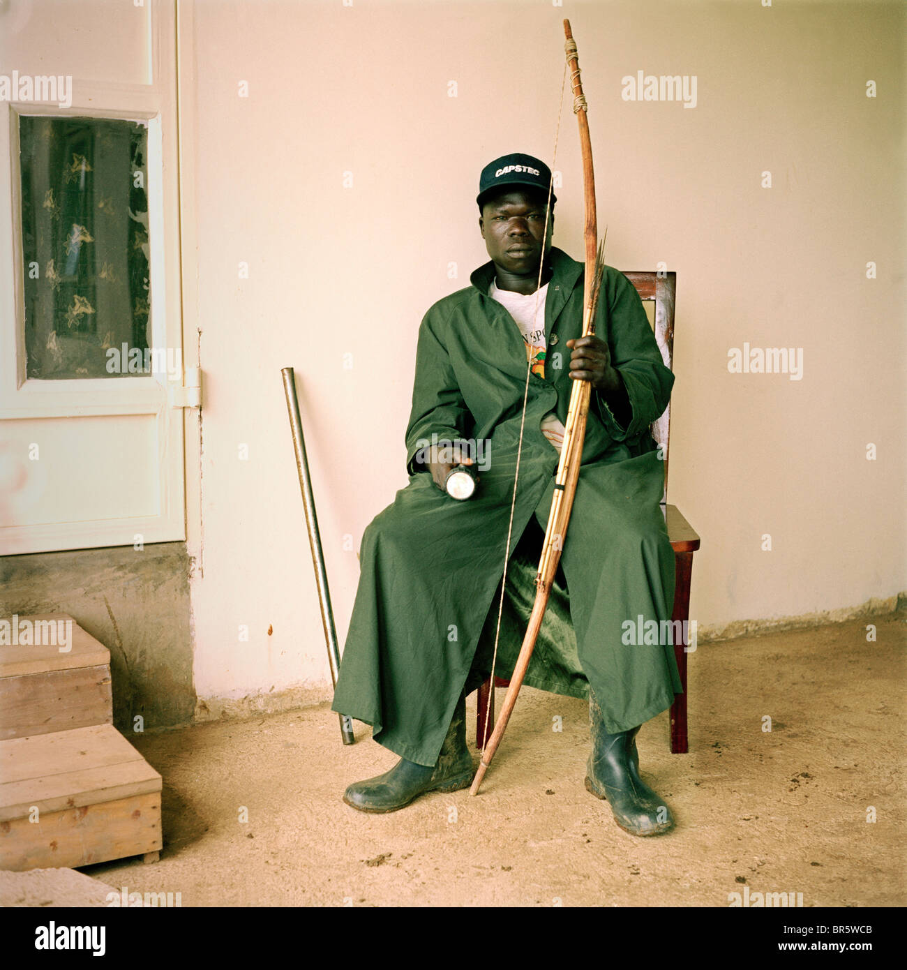 Michael Ezangu, guardia di sicurezza al Kulika Lutisi training center farm. Egli utilizza un arco e frecce per proteggere l'azienda. Foto Stock