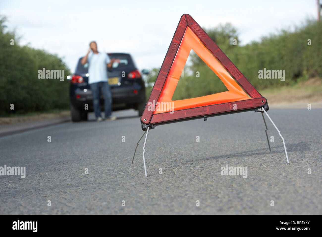 Autista ripartiti sulla strada di campagna con luci di avvertimento segno in primo piano Foto Stock