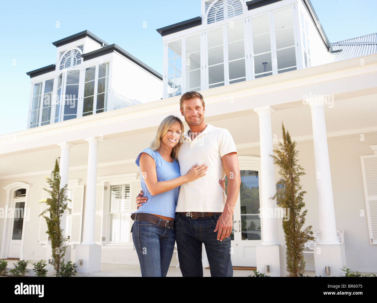 Coppia giovane in piedi fuori casa da sogno Foto Stock