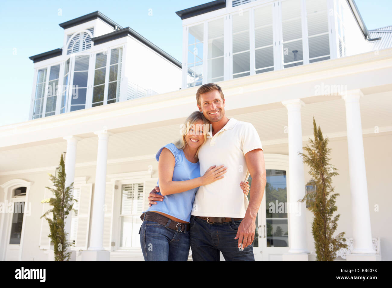 Coppia giovane in piedi fuori casa da sogno Foto Stock