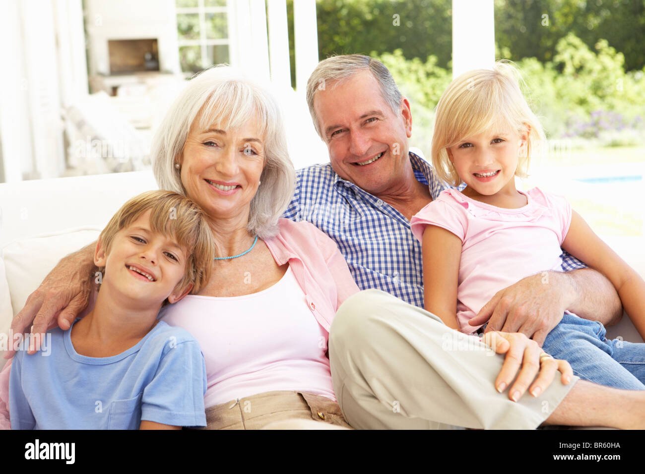 Ritratto di nonni con i nipoti rilassante insieme sul divano Foto Stock