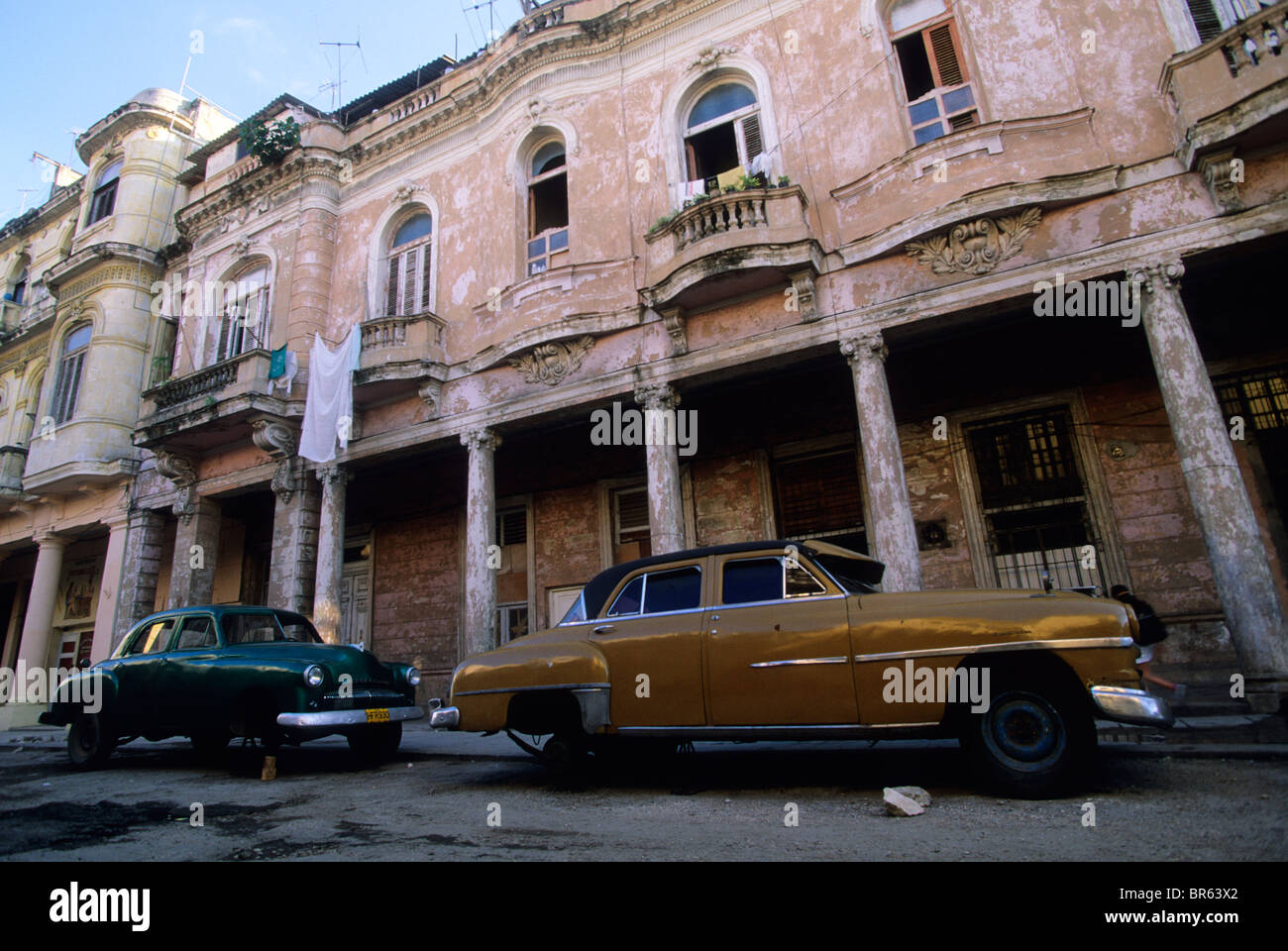 Vintage American cars su dei blocchi al di sotto di epoca coloniale buildiings Havana Cuba Foto Stock