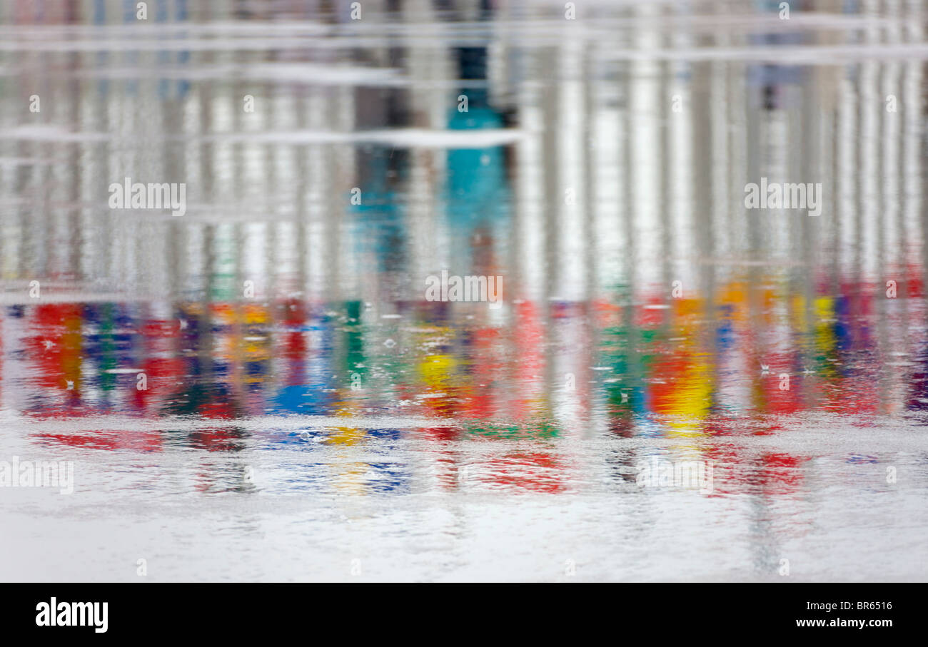 La riflessione di persone e di poli di bandiera sul terreno in caso di pioggia, 2010 Expo Shanghai, Cina Foto Stock