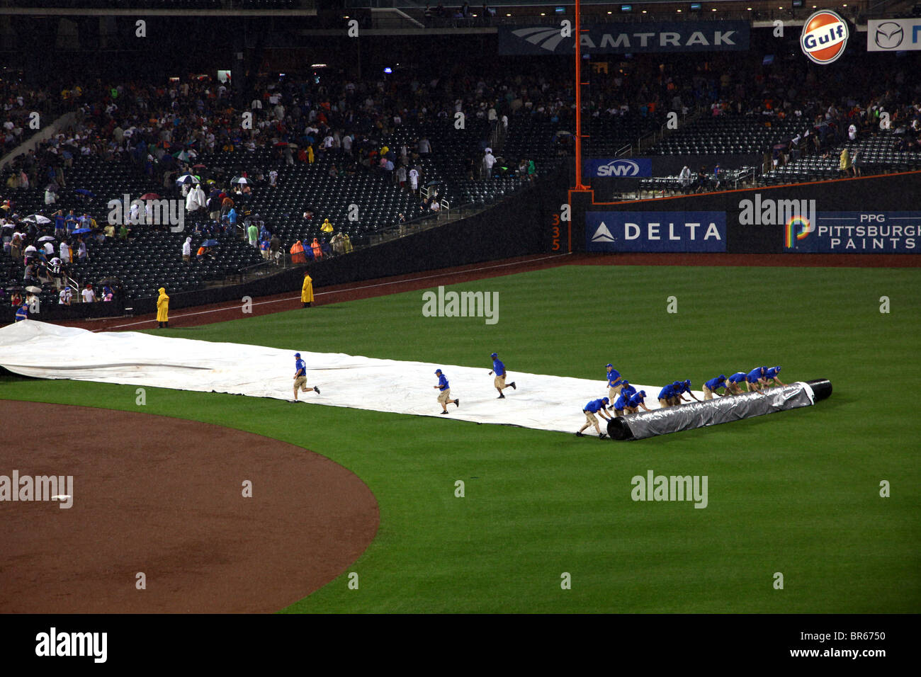 Citi Field motivi equipaggio di rollio del telo sul campo dopo un ritardo di pioggia, Queens, NY, STATI UNITI D'AMERICA Foto Stock