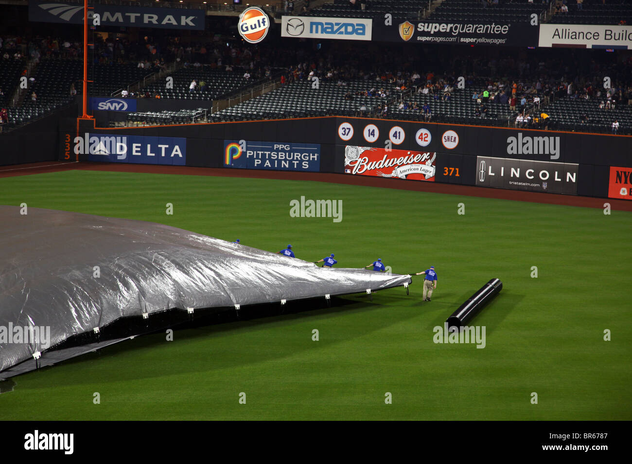 Citi Field motivi equipaggio tirando il tarp sul campo dopo un ritardo di pioggia, Queens, NY, STATI UNITI D'AMERICA Foto Stock