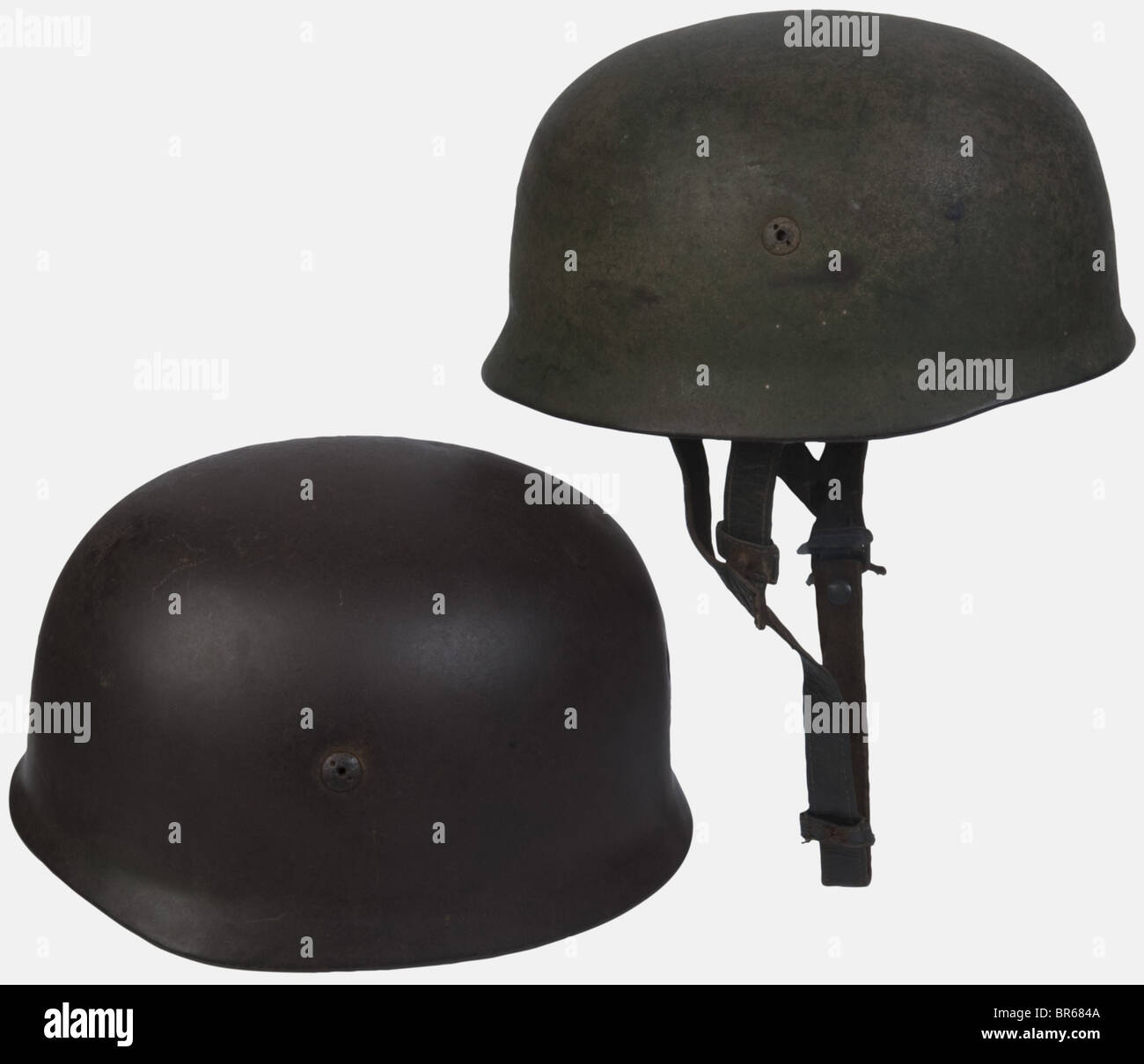 Luftwaffe, Deux coques de casque paracadutiste, l'une camouflée deux tons avec un insigne (aigle à 60 %), sans son intérieur, mais avec son cerclage en aluminium et ses jugulaires cuir complètes, l'autre ne comportant Plus de peinture. Raccordo unfilet de camouflage en corde, , Foto Stock