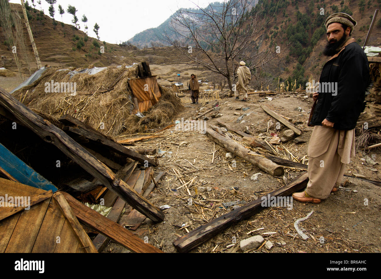 Gli uomini del villaggio di Gangwal che fu devastato nel 2005 Terremoto visualizza rifugi di fortuna che gli abitanti di un villaggio costruito Foto Stock