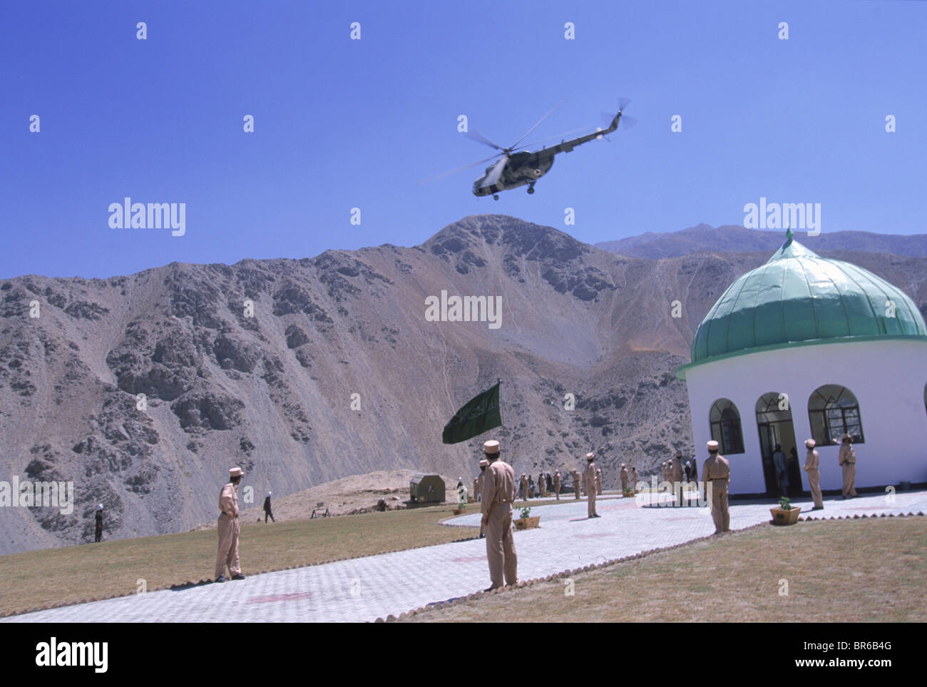 Le protezioni stand presso l'attenzione come elicotteri volare in salute oltre il santuario di Ahmad Shah Massud nel Panjshir Valley Foto Stock