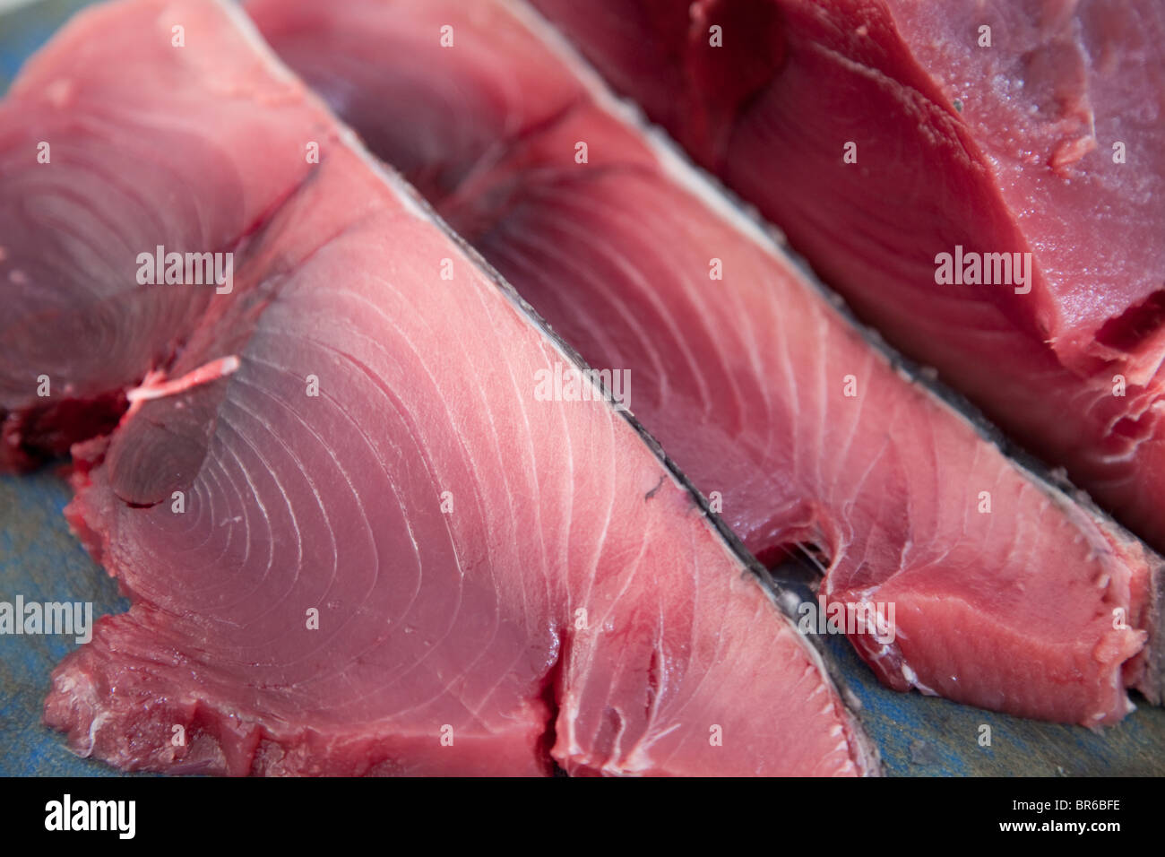 Tonno rosso bistecche e un pezzo di tonno non tagliato la carne su un tagliere a un pescivendolo in Malta. Foto Stock