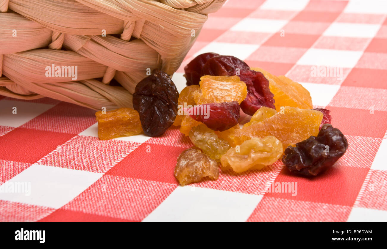 Frutta secca di albicocca, uva sultanina, uva passa e mirtilli rossi si versi sulla rosso e tovaglie bianche. Foto Stock