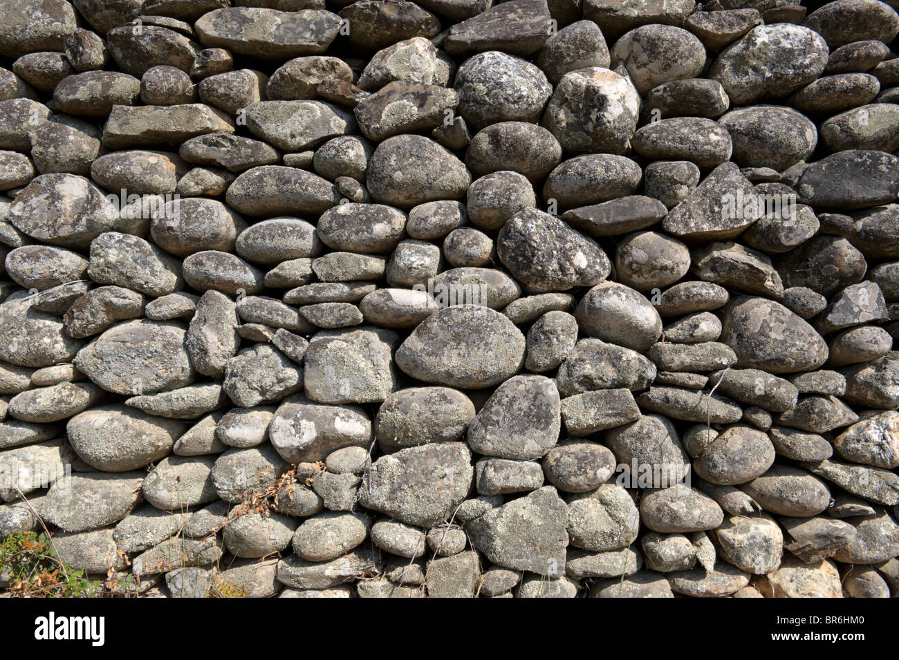 Tradizionale di pietra parete realizzata con rocce rotonde Foto Stock