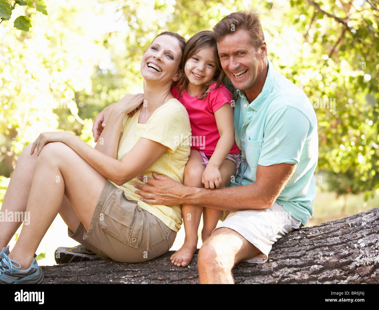 Famiglia seduta su albero in posizione di parcheggio Foto Stock
