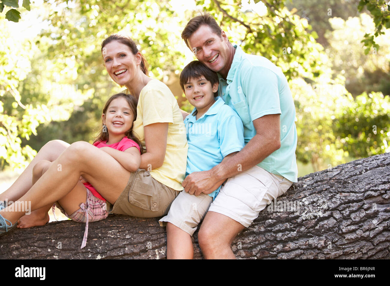 Famiglia seduta su albero in posizione di parcheggio Foto Stock