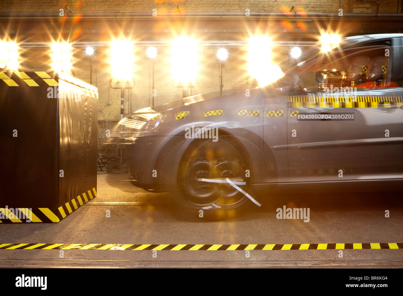 Un crash test car con un crash manichino di prova la guida in una barriera Foto Stock