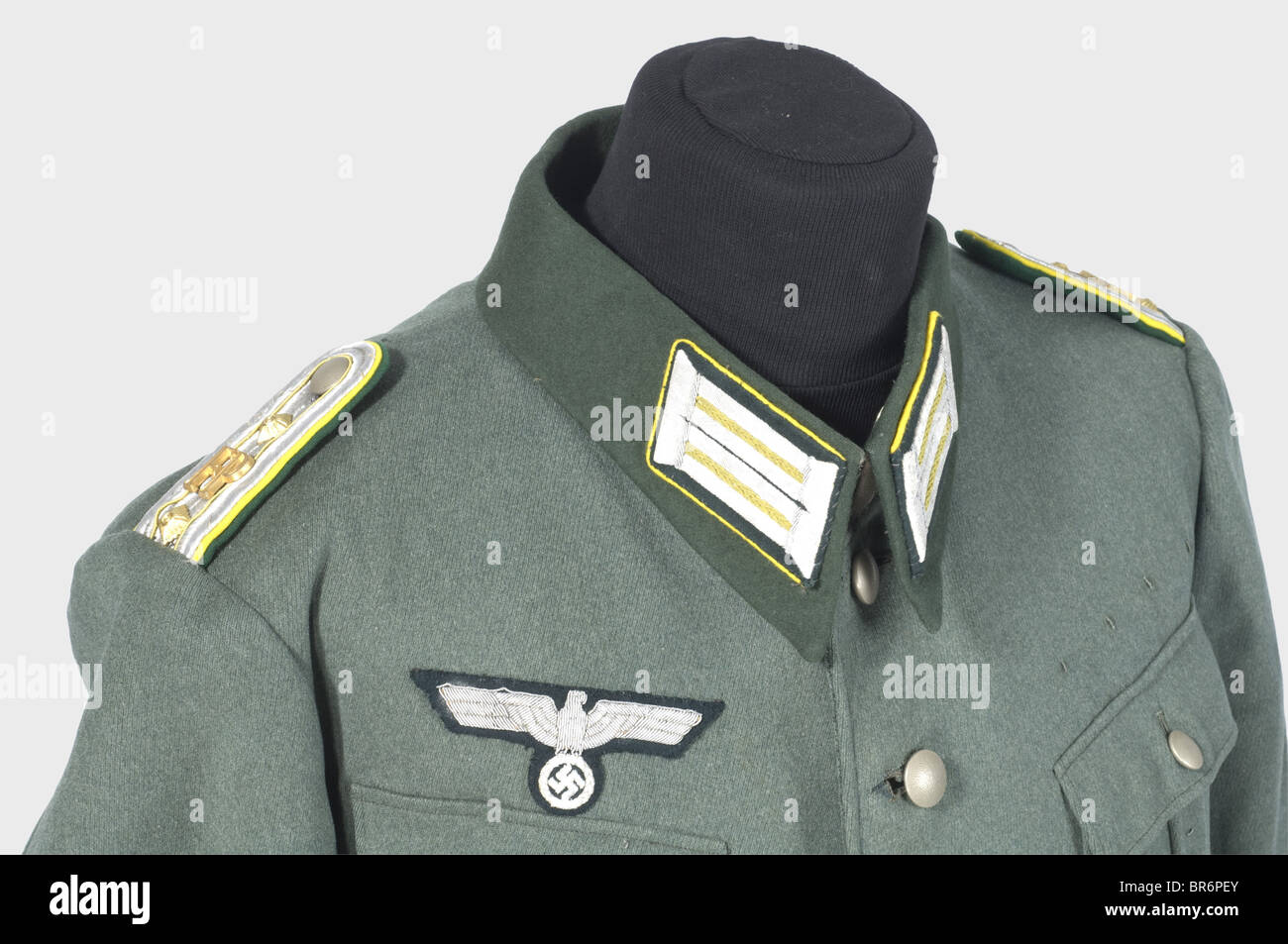 Un ensemble uniforme per un ispettore postale di campo., una tunica gabardina grigia di campo con collare verde scuro (falle di falena), aquila pettorina ricamata in argento e anelli di medaglia. Le chiazze da collare e gli spalline hanno una tubazione gialla di limone, le spalline hanno un cordone giallo e visualizzano le lettere 'FP'. Nessun bracciale. Un soprabito in lana grigio con colletto verde scuro, supplicine e francobolli di dimensioni nel rivestimento, e spalline cucite come la tunica. Braghe di gabardine grigio pietra con cinghie per le gambe e finiture in pelle. Sacco da campo bloccabile con una fessura di deposito posta, recante il , Foto Stock