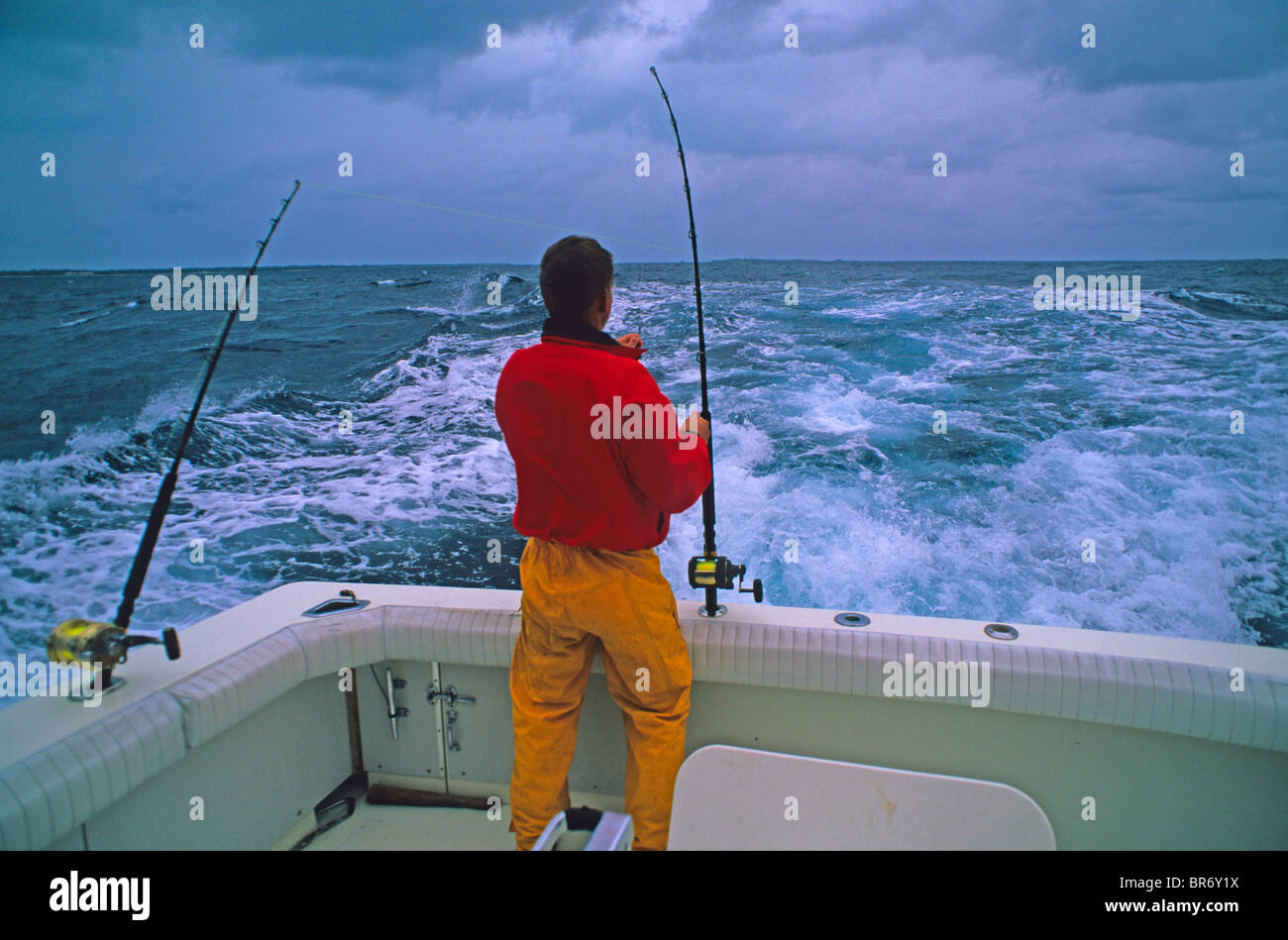 Un pescatore DI ATTREZZATURE VELICHE trolling linee per Big Game pesce nell'Oceano Pacifico off atollo di Midway Hawaii. Foto Stock