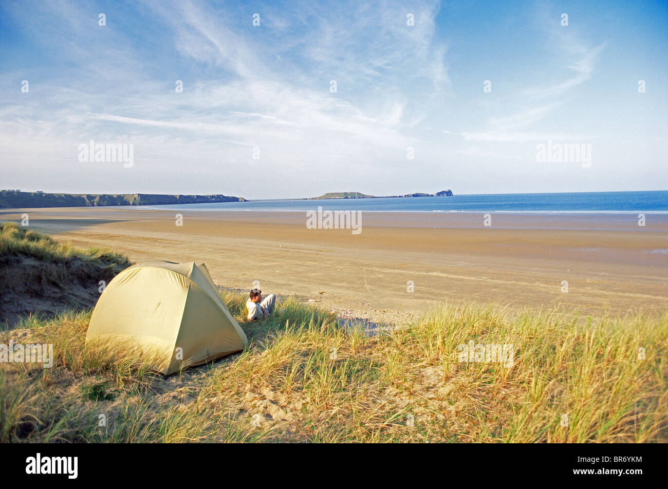 L'uomo campeggio a Rhossilli Bay beach, Penisola di Gower, West Glamorgan, Galles Foto Stock