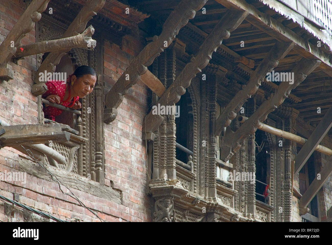 Newar donna a guardare fuori dalla finestra in Nepal. Foto Stock