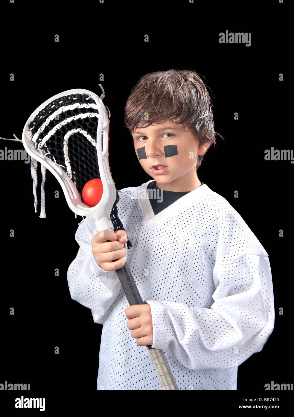 Un sudato ragazzo giovane pone con la sua lacrosse stick (crosse) dopo una partita. Foto Stock