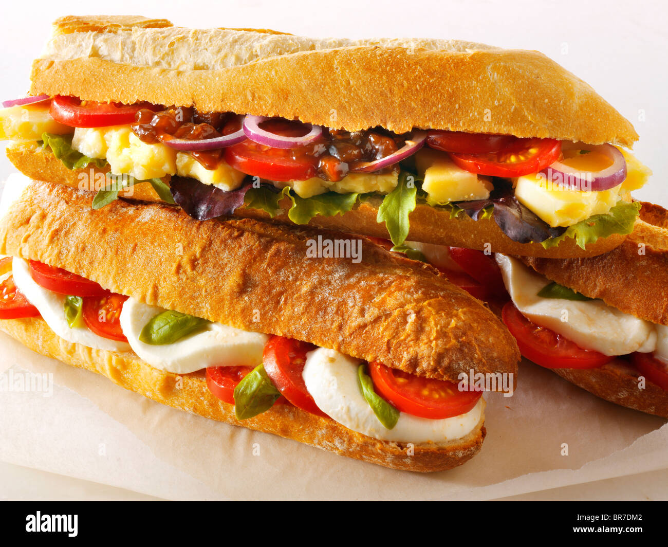 Pane baguette riempito con mozerella & i pomodori e il formaggio cheddar plowmans con chutney Foto Stock